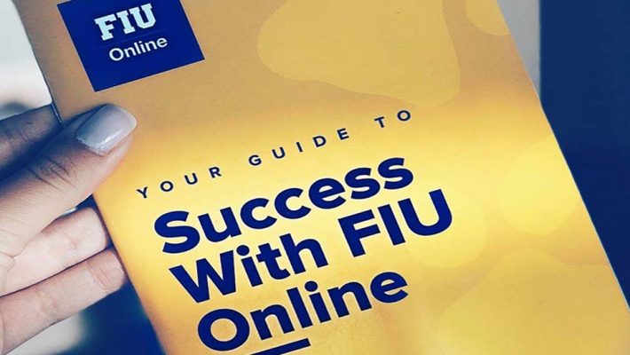 Hand holding a booklet with FIU Online logo; cover reads Your Guide to Success with FIU Online